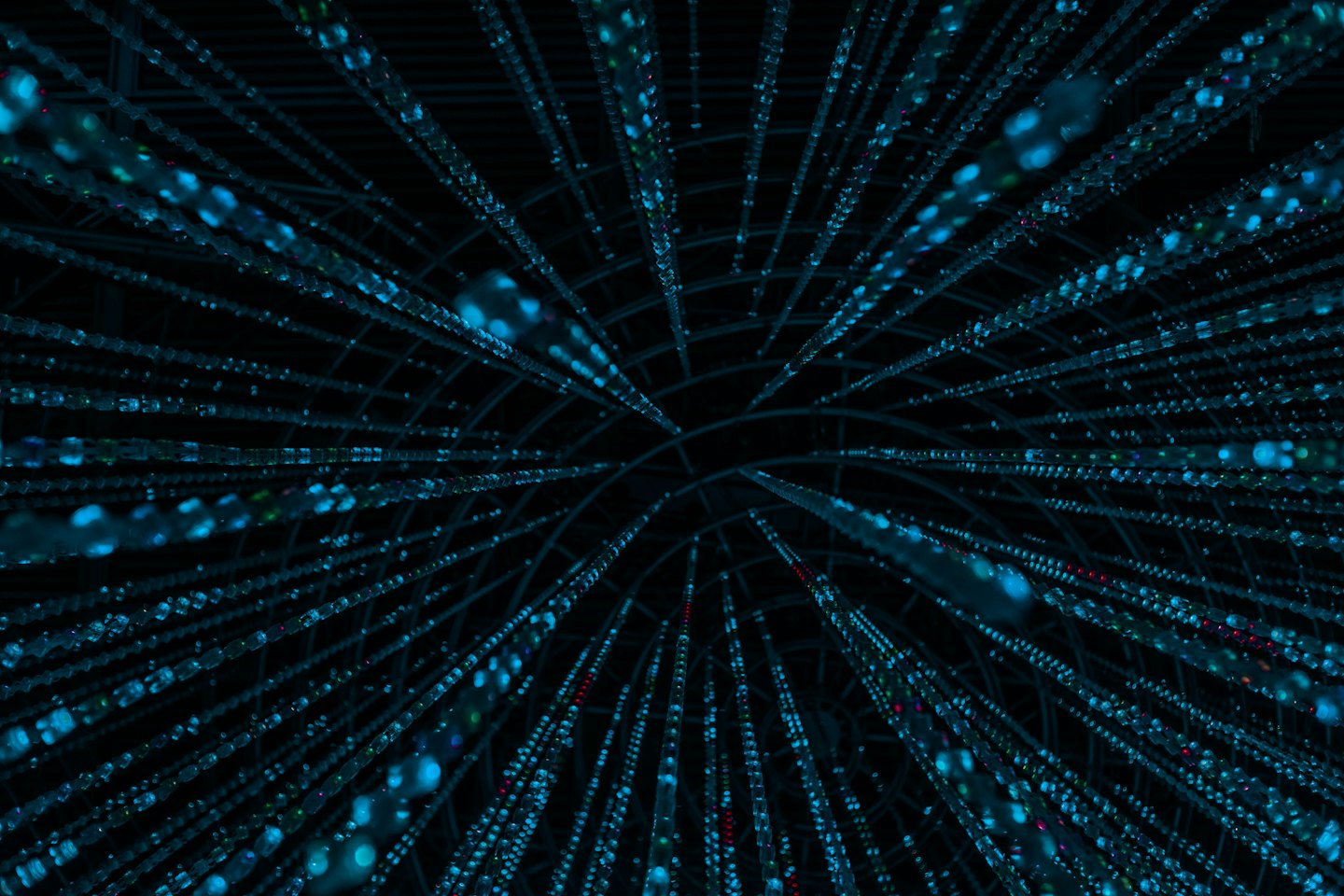 Glowing blue fiber optic strands converge toward a central point.